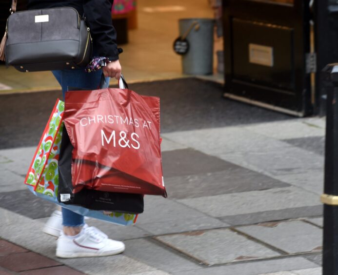 Woman holding M&S shopping bag