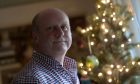 James Suddick in front of a Christmas tree