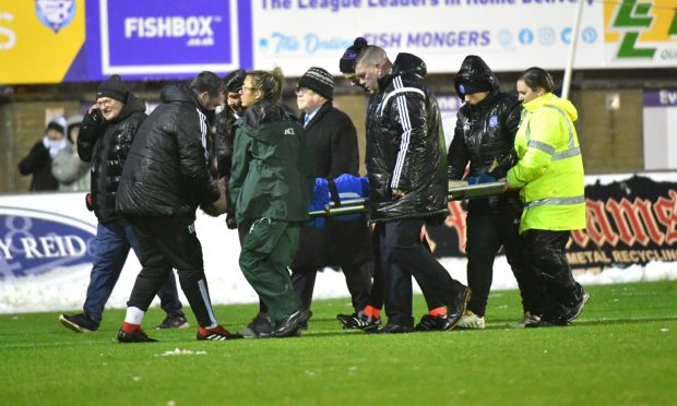 Peterhead's David Wilson is stretchered off with a neck injury against Forfar Athletic. Image: Duncan Brown.