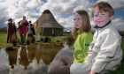 10 year old Victoria Duncan and Alex Gaynor,6, listen to traditional music by the water at  Archaeolink's Celtic Spring Fair. Image: DCT/Kevin Elmslie