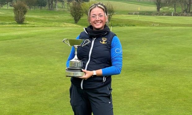 Murcar Links' Robyn Fowlie on the green holding a trophy