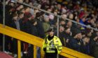 A police officer guarding fans at Pittodrie. Image: Andrew Milligan/PA Wire