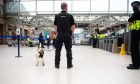 Police aided by police dog, Hamish, checking passengers as they exit the platform at Aberdeen Train Station.