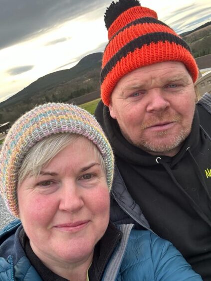 Tracy and Graham Chalmers with their knitted hats.