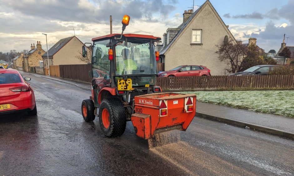 Orange gritter seen out gritting the street.