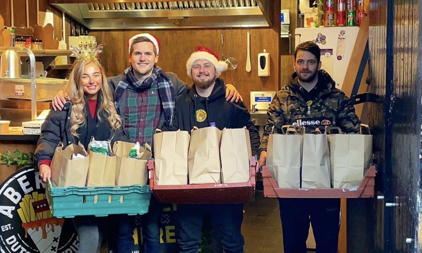 Aberdam staff standing with festive food parcels in trays.