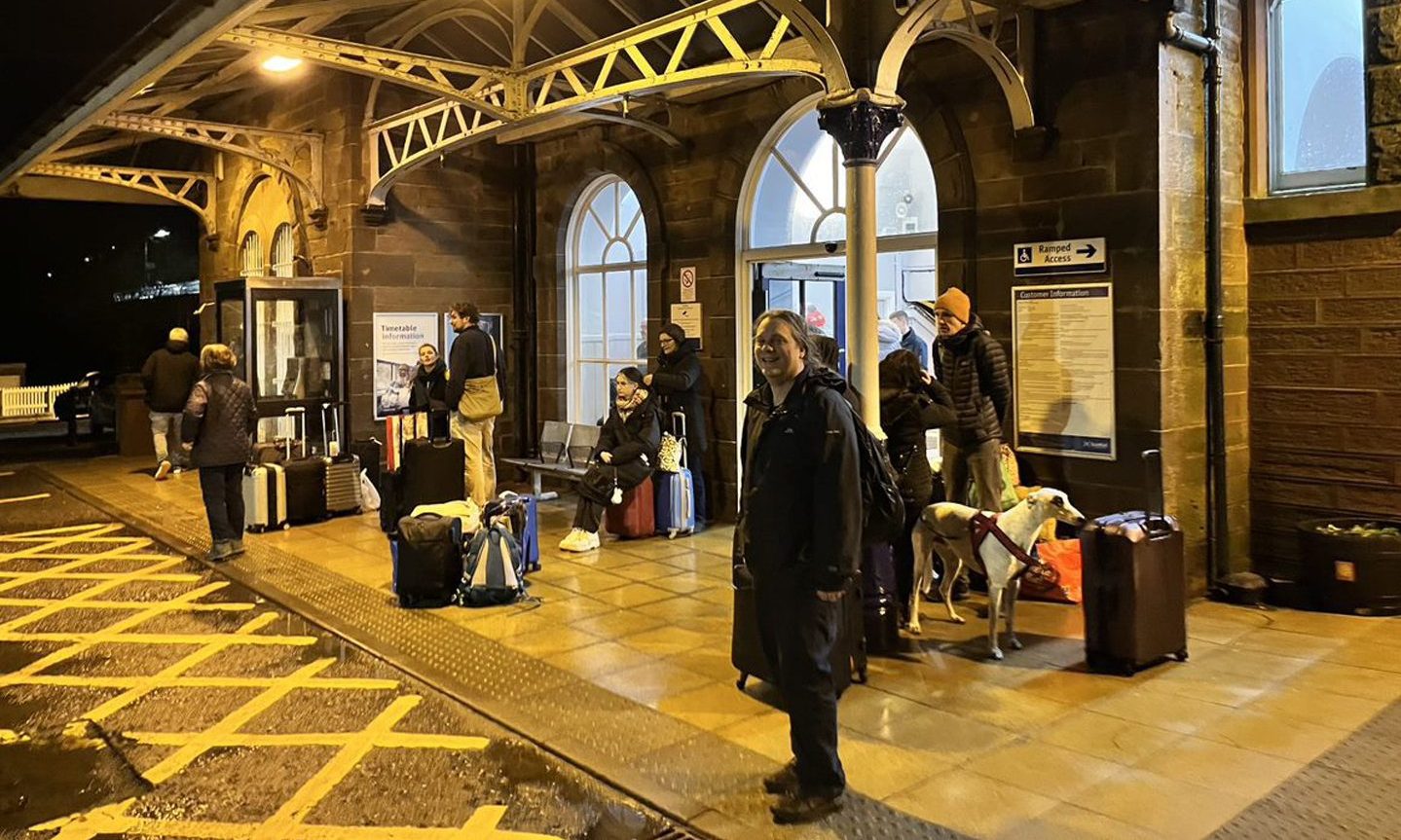 Niall Atkinson, 32, waits outside Stonehaven station with other stranded passengers after a cancellation due to Storm Gerrit.