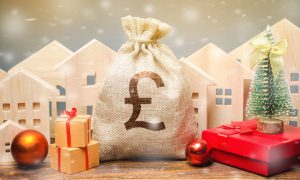 Money bag, wooden houses, Christmas tree and gifts.