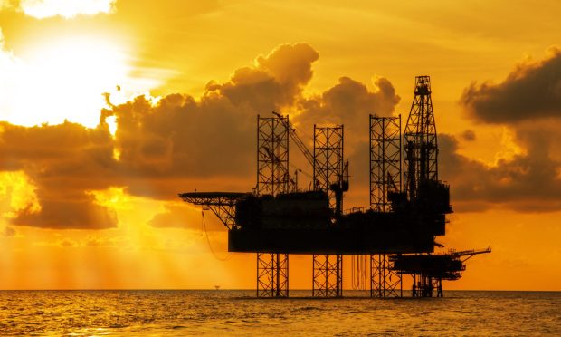 An offshore jack-up rig at sunset.