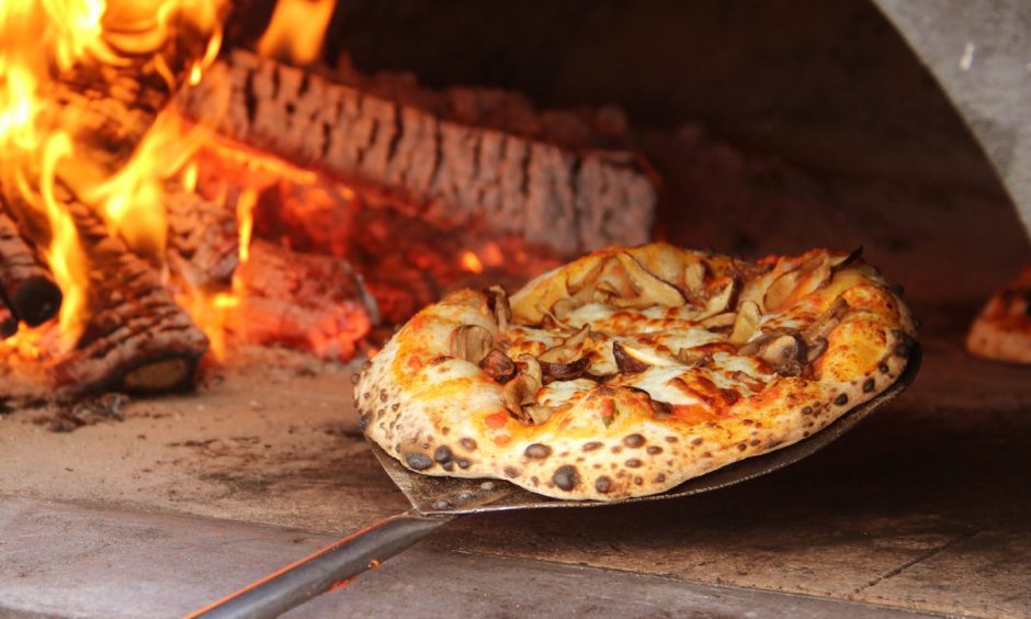 A pizza in a stone pizza oven