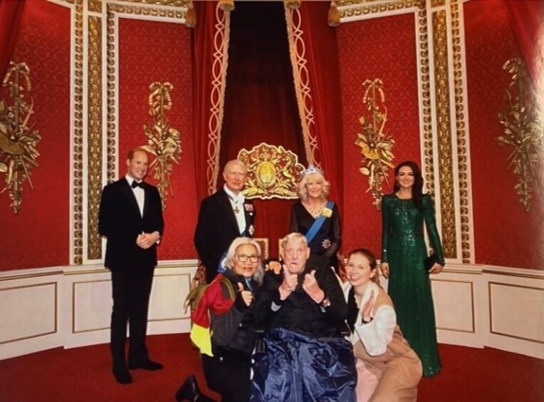 Aberdeenshire care home resident Willie McIntosh poses with waxworks of the royal family.