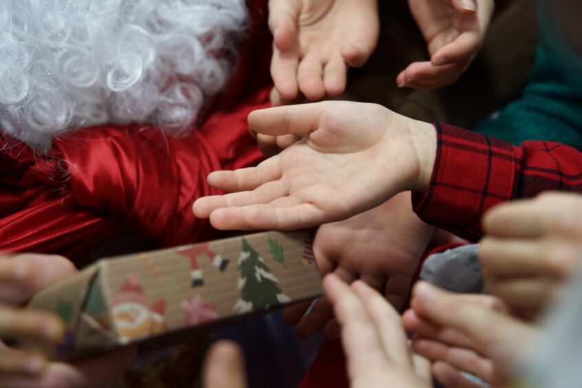 Santa Claus hands out gifts to Ukrainian refugee children during the Christmas celebrations in Aberdeen.