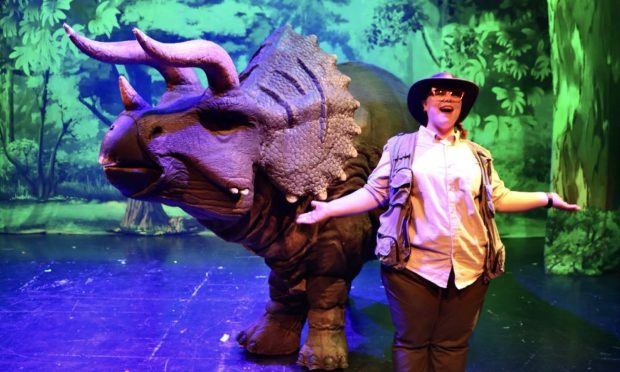 Jurassic Live the musical adventure with a ranger and dinosaur puppet on stage.