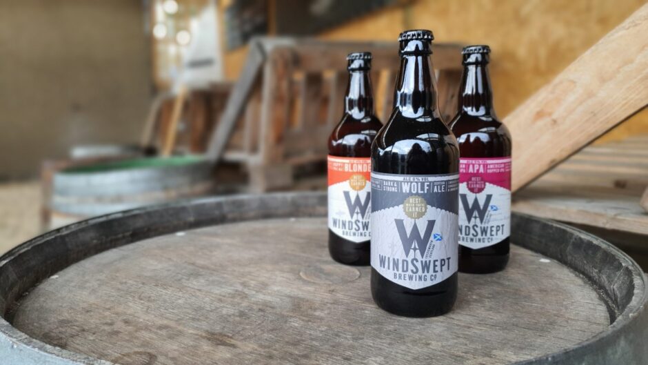 Three bottles of Windswept Brewing Co beers on a barrel. 
