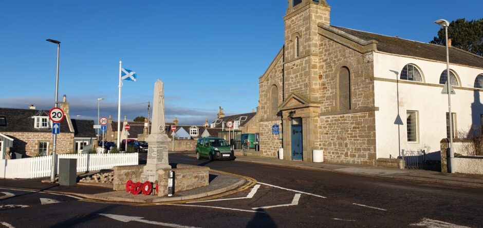 Saltire flag with war memorial in front.