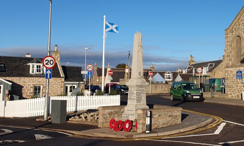 Saltire flag with war memorial in front. 