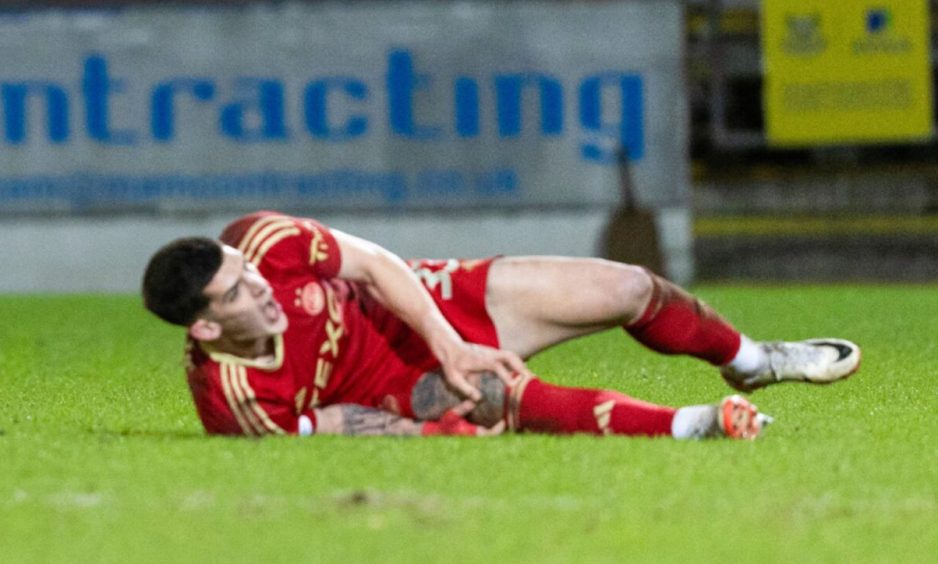 Aberdeen defender Slobdan Rubezic holds his knee after suffering an injury in the 1-1 draw at St Johnstone. Image: SNS