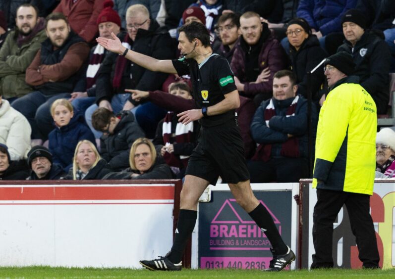 Referee Kevin Clancy awards Hearts a penalty against Aberdeen after he consults the VAR monitor. 