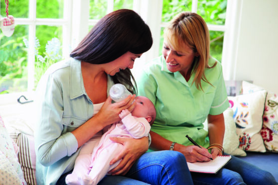 Mother and baby meeting with a health visitor at home. Image: Shutterstock