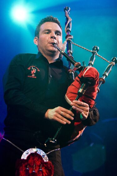 Stuart playing under he stage lights with the Red Hot Chilli Pipers in 2009
