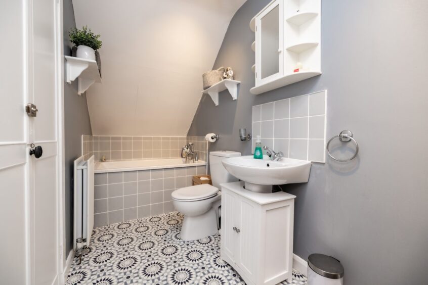 Bathroom featuring bathtub and mosaic style flooring.