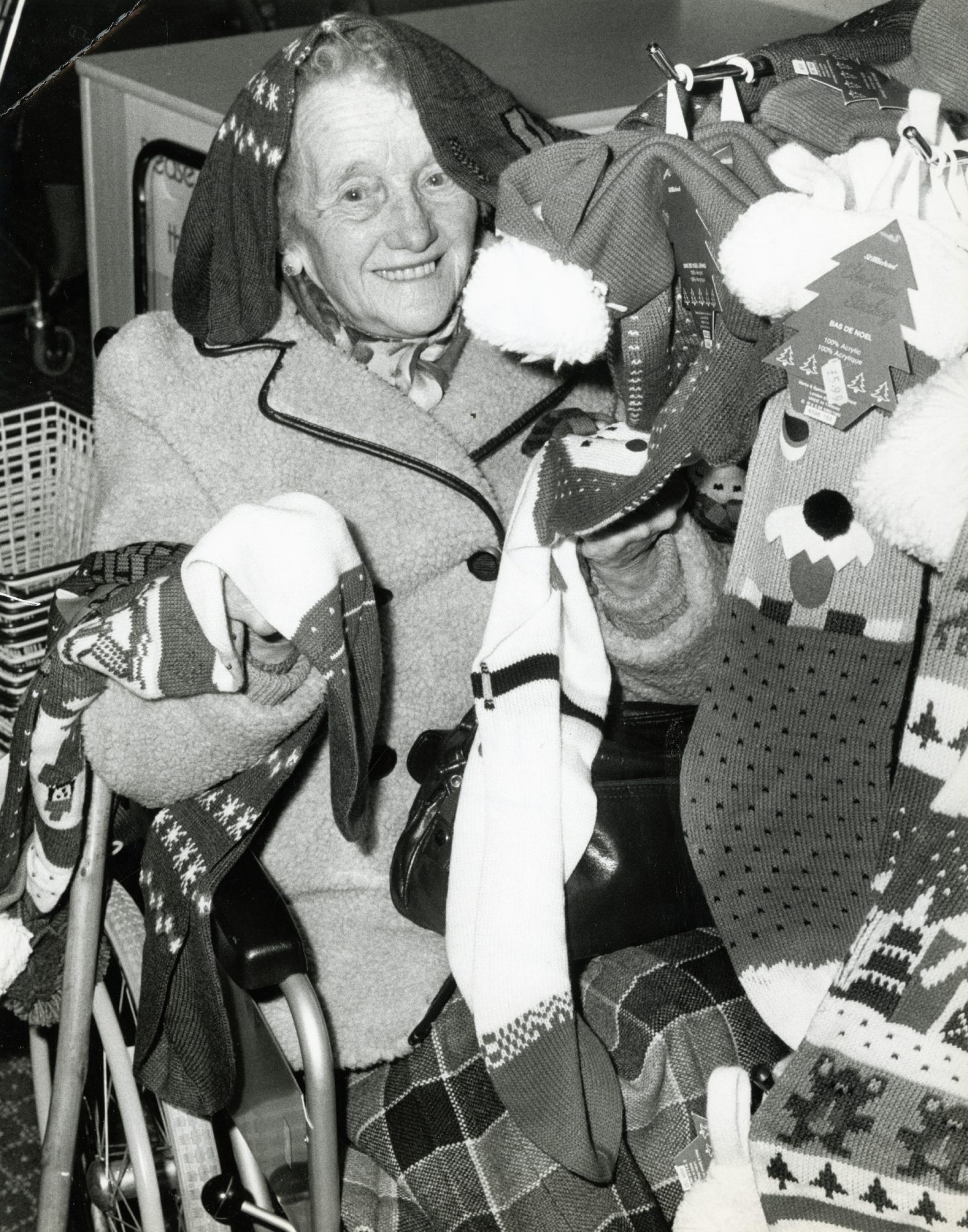 An elderly woman in a wheelchair surrounded by christmas stockings