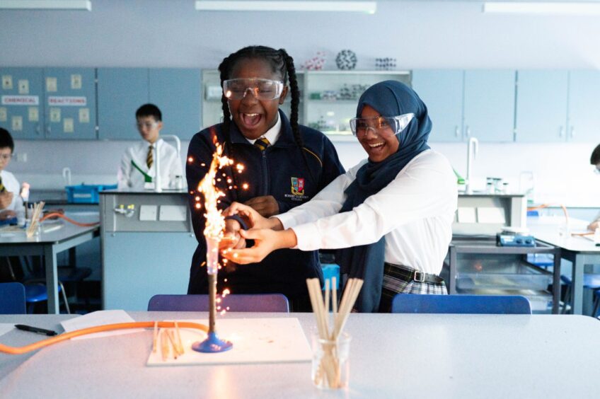 Robert Gordon's pupils with bunsen burner in science lab.
