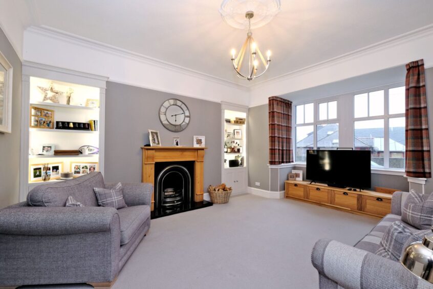 The living room with a grey colour scheme, fireplace and two bookcases