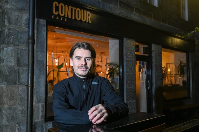 Liam Urquhart poses outside the Contour Cafe,