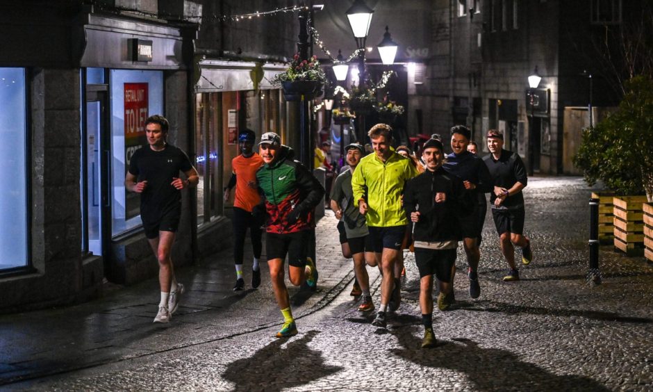 Members of The Green Running Club jog up The Green in Aberdeen ahead of an evening run.