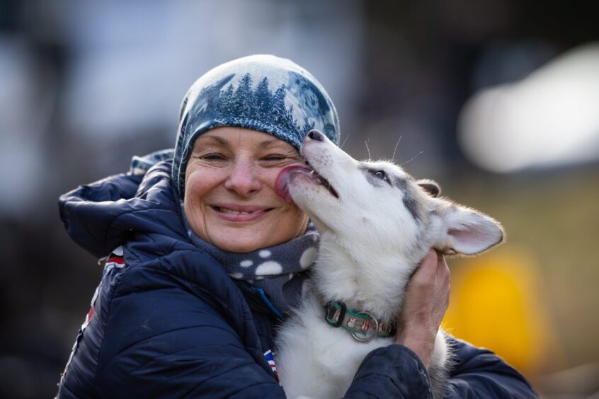Dog licking woman's face.