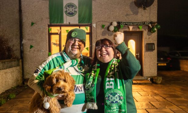 Buckie Thistle fans Andy Murray, left, and wife Amanda with their dog Hector in front of their house decorated in Buckie colours. Pictures by Jason Hedges/DCT Media