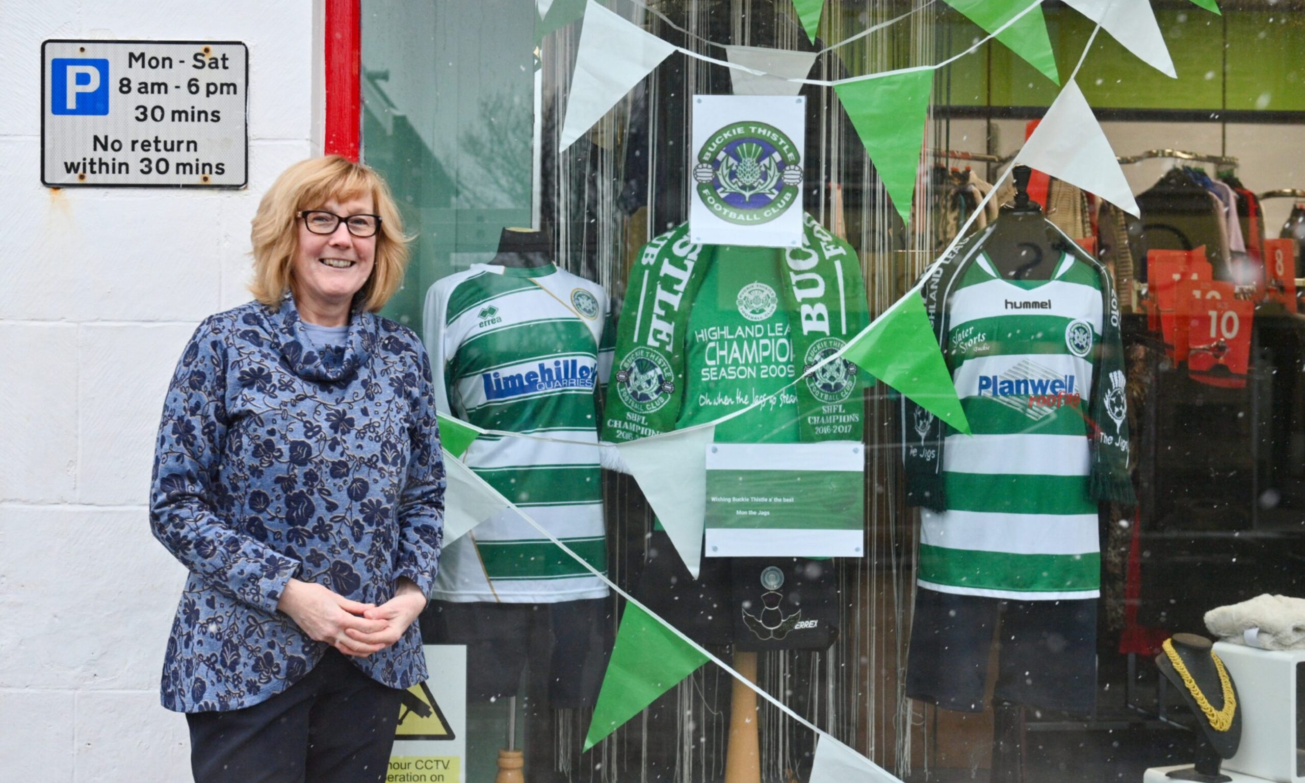 Shop window decorated with Buckie Thistle strips and bunting. 