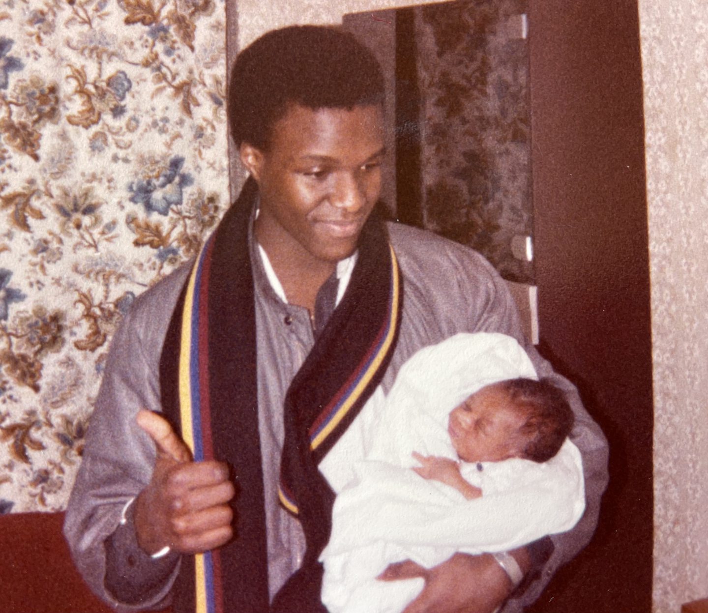 James N'Dow holding a baby in London in 1986