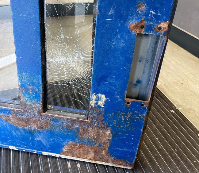The broken front door at Cairncry Court in Aberdeen.
