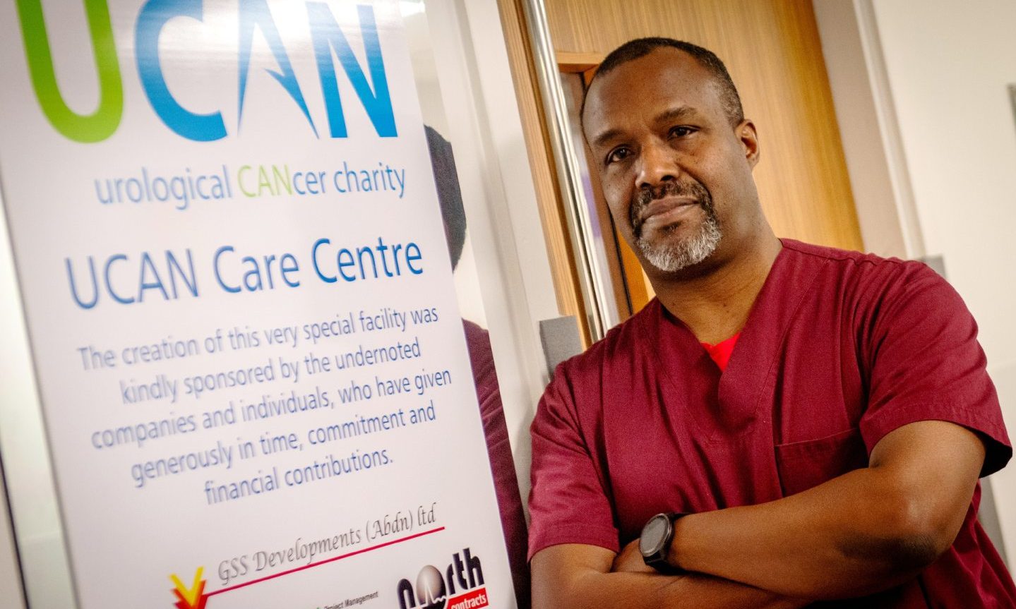 James N'Dow stands next to a UCAN sign in the UCAN centre in Aberdeen