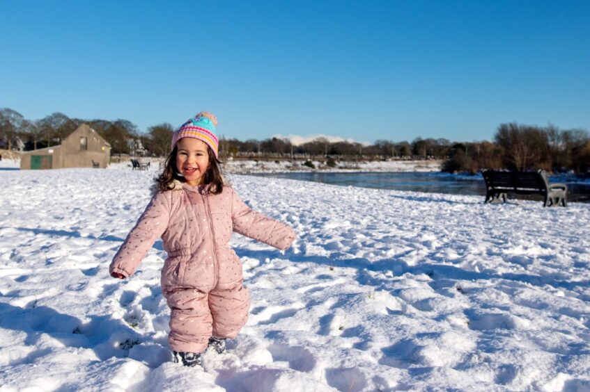Little girl standing in snow.