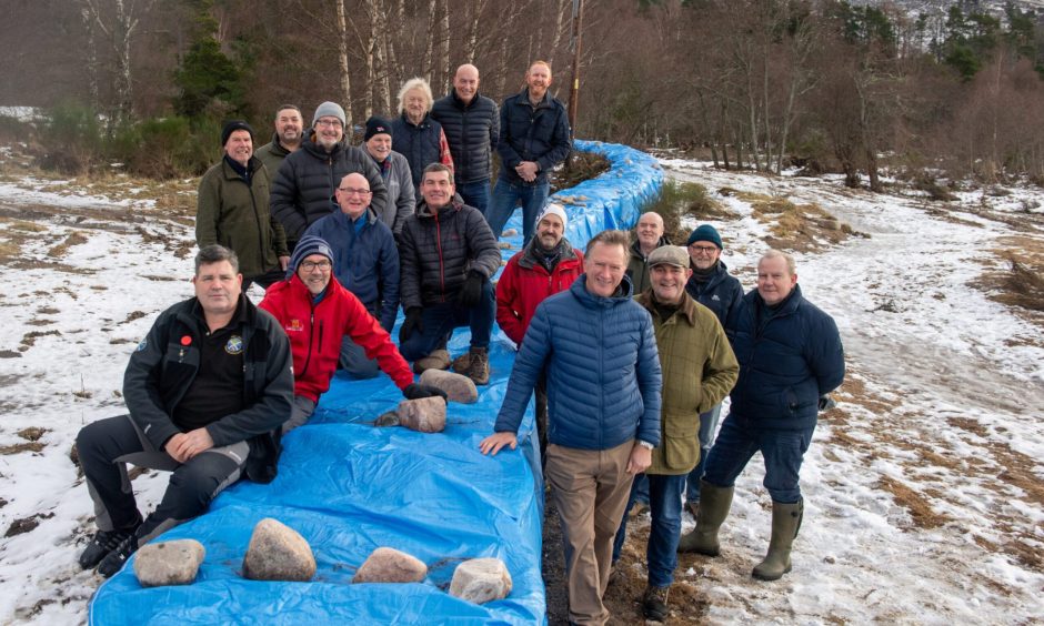 Pictured are volunteers at the newly built flooding defence at the River Dee in Ballater.