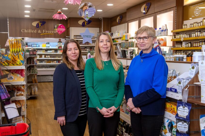 Grampian Health Foods former owner with the new owners inside the shop