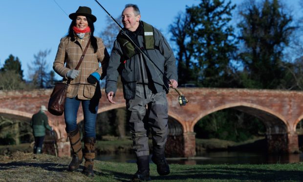 Our writer Gayle Ritchie hangs out of the banks of the River Tay at Meikleour with Paul Whitehouse. Image: Kenny Smith.