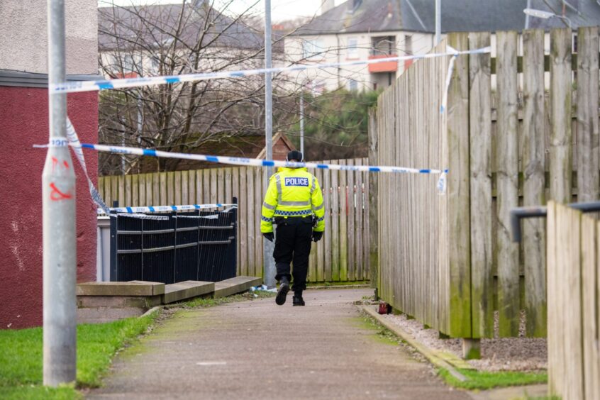 Police officer at path behind houses on Hayton Road, Tillydrone.