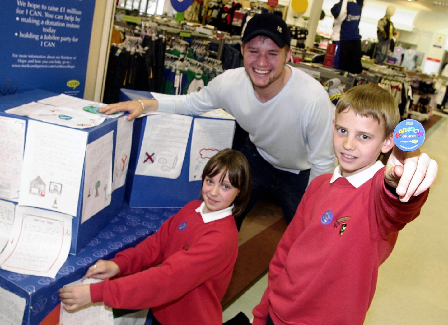 Aberdeen FC player Kevin Rutkiewicz and two school pupils in front of a stall display