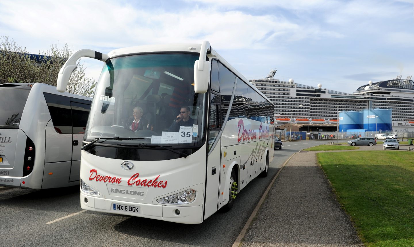 Coaches with cruise ship in background. 