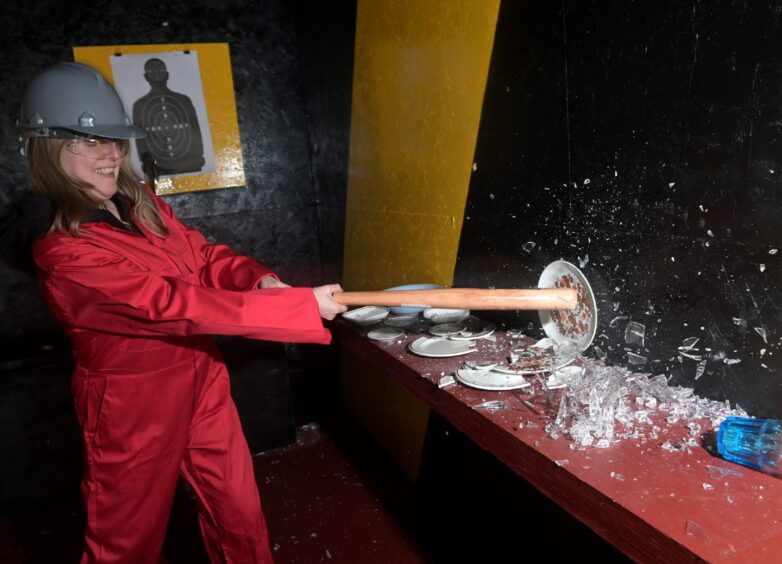 Reporter Rita Campbell smashes crockery at a rage room in Aberdeen.