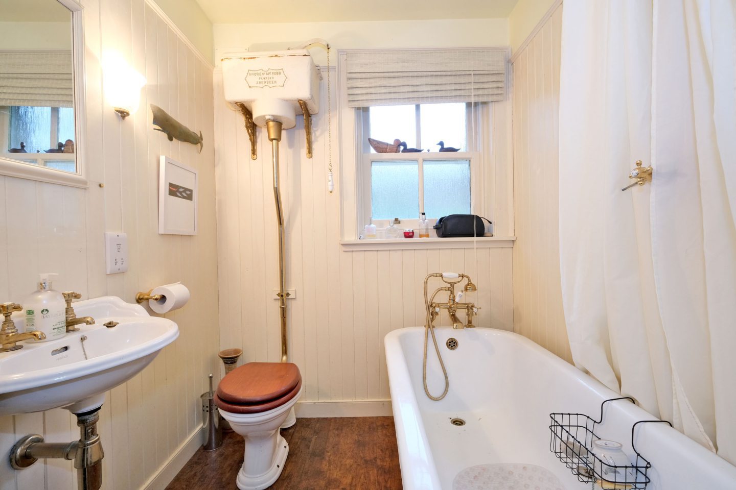 Traditional bathroom in the artist's Aberdeen home, featuring high cistern and freestanding oval bath.
