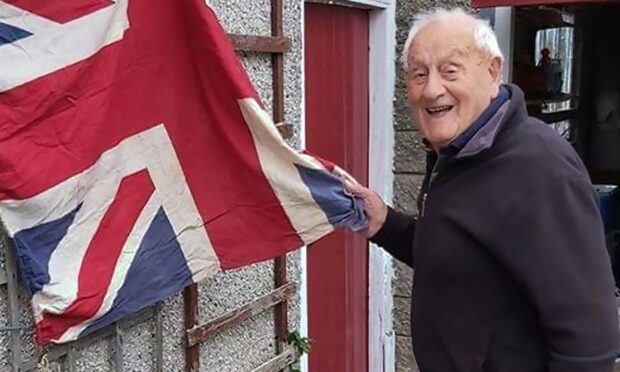 Sandy Mutch with the flag he waved in Cyprus to celebrate the end of the Second World War.
