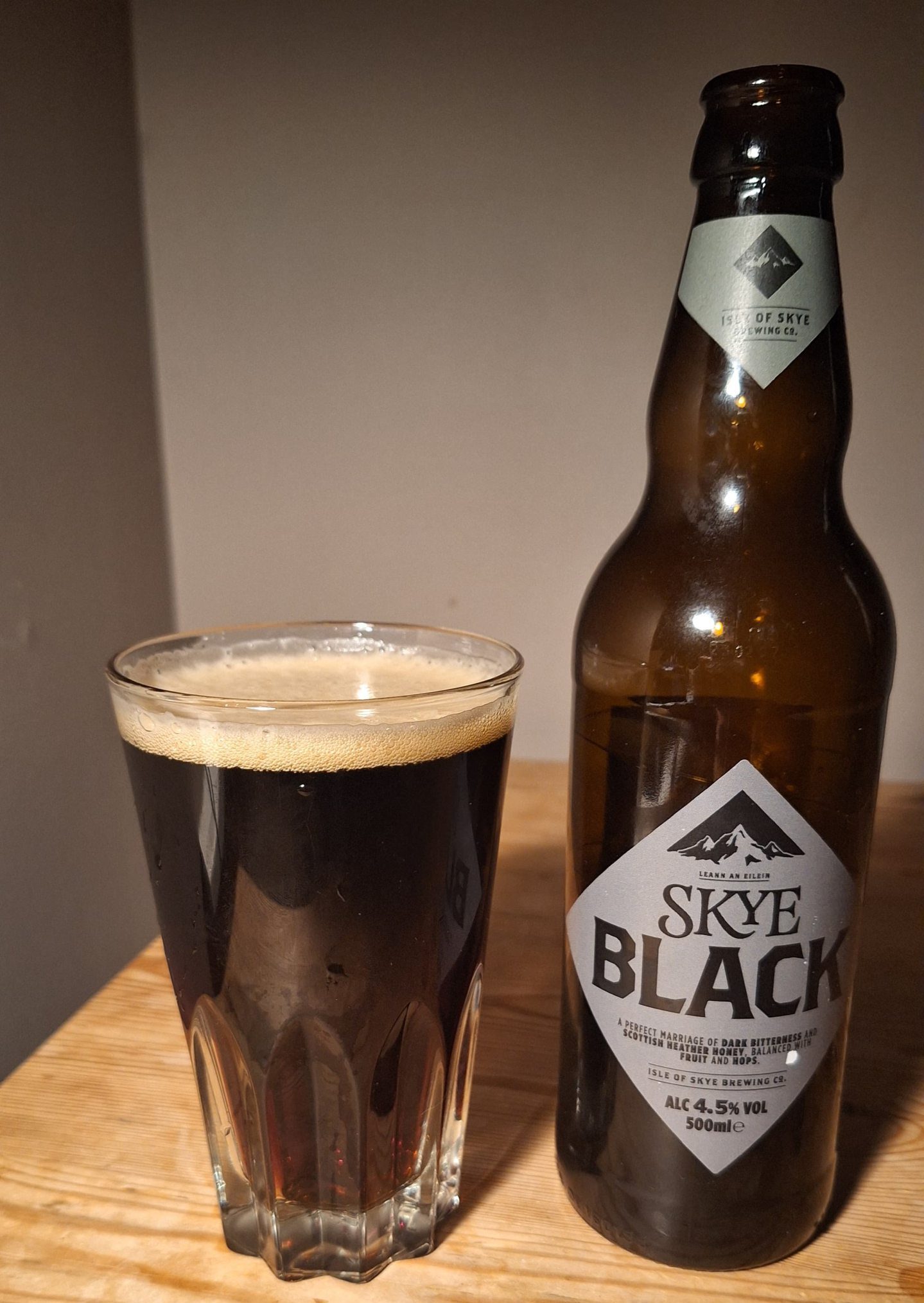 A bottle of Skye Black beer poured out into a glass. 