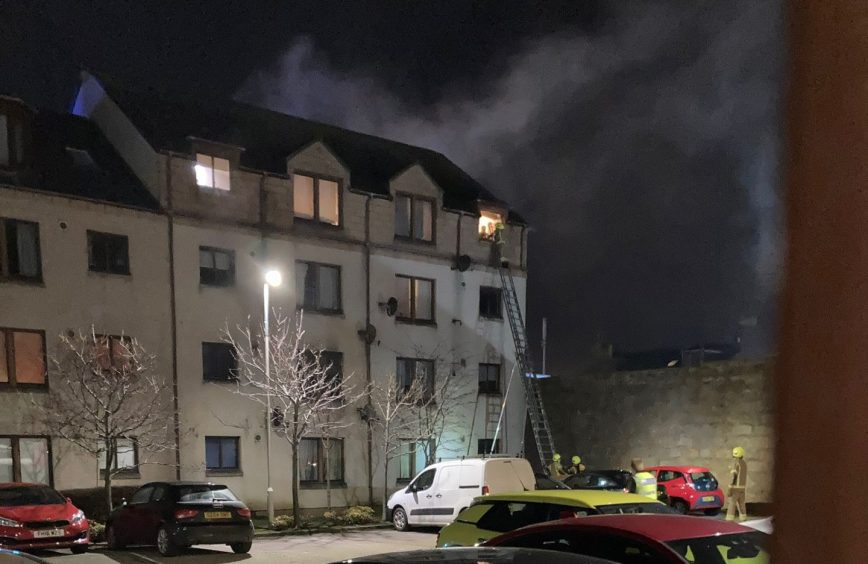 Firefighters rescuing someone from burning flat 