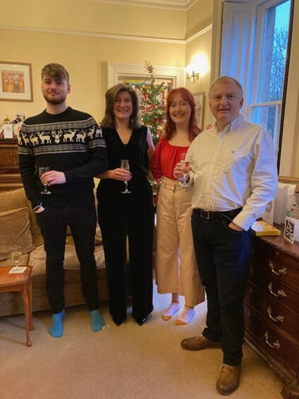 Kevin standing with this wife and two children at Christmas. 