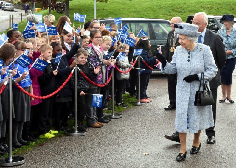 Queen Elizabeth II waves to pupils from Abbotswell School during a visit to Sue Ryder in Kincorth, Aberdeen. Image: Jim Irvine/DC Thomson